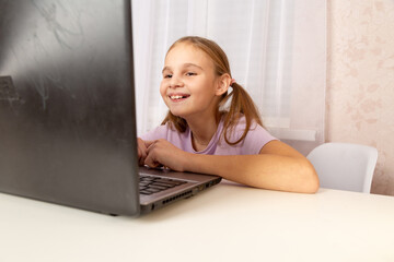 Schoolgirl does her homework using a laptop