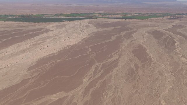 The Nazca Desert in Peru and the green river valley from the window of a Cessna airplane