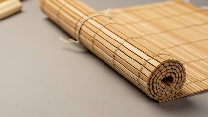 Rolled bamboo mat with intricate woven texture on a neutral surface