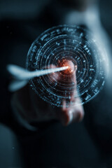 Arrow hitting bullseye target with hand reaching towards it in dark background