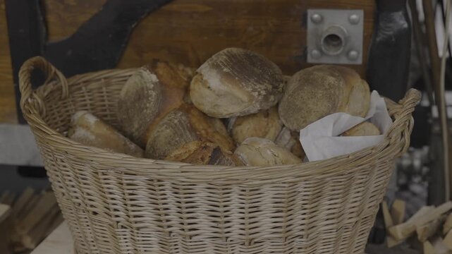 Close-up of artisanal bread in a woven basket, baked in an oven inside a wooden booth at a Christmas market. Rustic festive bakery display with authentic holiday charm