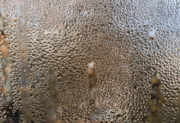 Water droplets clearly visible on a window surface. window with condensation visible as moisture droplets. the surface of the wet glass. Abstract background for creatives.