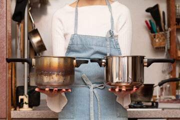 古い鍋と新品の鍋を持った女性の手元