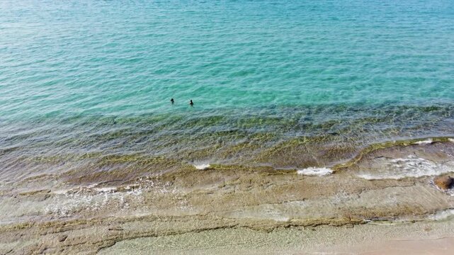 Two People Swimming in the Crystal Clear Turquoise Waters of Sani Beach, Halkidiki, Greece