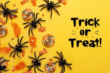 Halloween treats and spooky spider decorations on a bright yellow background with text