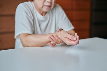 手首を押さえるシニア女性