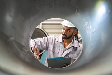 Inspection process in industrial setting engineer evaluating pipe quality factory professional...