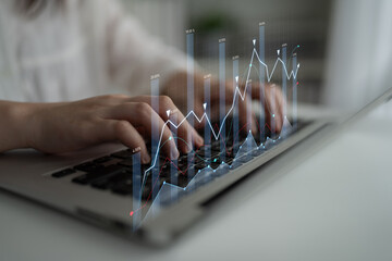 A focused individual interacts with a laptop keyboard while digital graphs and charts display market trends, showcasing the integration of technology and finance in a modern workspace. Scalp