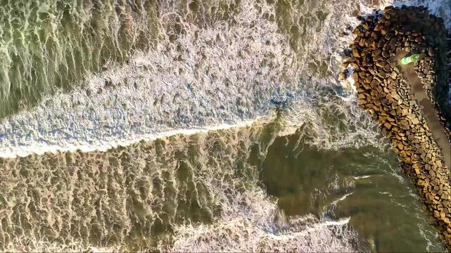 Vista aerea duma praia com ondas a formarem espuma