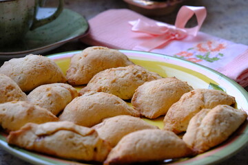 Fresh apple cookies, fresh from the oven. A Turkish-embroidered napkin with a pink ribbon. A pink floral decorative plate. Homemade cookies. Turkish cuisine. Tea time. Ramadan iftar. A green cup.