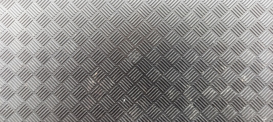 Silver textured surface with a repeating diamond pattern and a brushed metal finish
