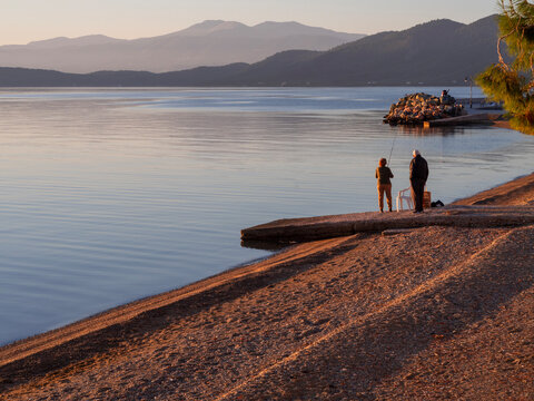 A female fisherman fishing in the Aegean Sea at sunset on Evia Island in Greece 