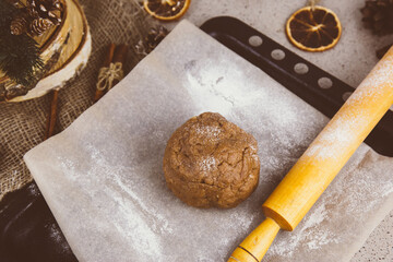 Christmas lifestyle with gingerbread cookies, dough and flour on dark background. Top view. Free space. Flat lay.