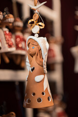 christmas tree decorations, h andcrafted terracotta angel ornament with white glaze accents and cut-out details. Traditional German ceramic decoration hanging at the Christmas market