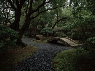 Fototapeta premium tranquil japanese garden with stone bridge and lush greenery