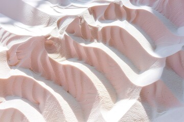 Shadows create patterns in warm sand with gentle curves. The light reveals soft textures and gradients from light to dark during midday under the sun