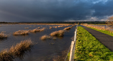 Fototapeta premium Flooding and rainbows along a path Anglesey