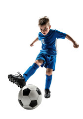 Fototapeta premium young caucasian boy in blue soccer uniform powerfully kicking a ball, frozen action shot with high-contrast studio lighting on a transparent background. concept of athletic determination