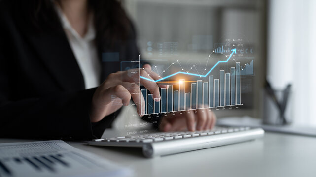 A businesswoman analyzes growth data in a modern office, using digital graphs and charts to drive strategic decisions and enhance performance. Scalp