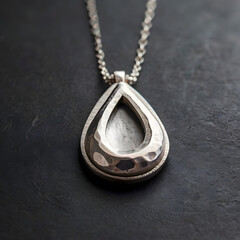 An elegant silver pendant of a teardrop design, reflecting light on a dark backdrop, perfect for jewelry or fashion design needs.