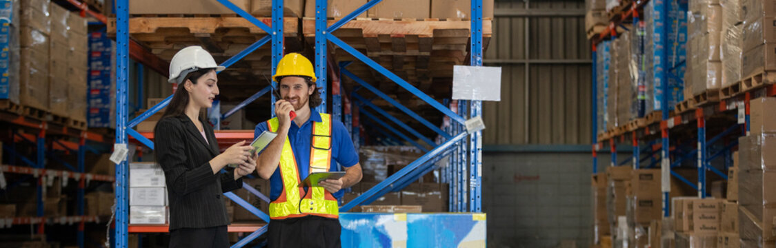 Female supervisor and warehouse man worker using tablets and walkie-talkie to discuss logistics operations. Team coordination in modern warehouse environment with smart inventory management. - Powered by Adobe