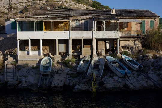 Barchette di pescatori in riva al mare davanti a delle case nelle calanques di Marsiglia in Francia.