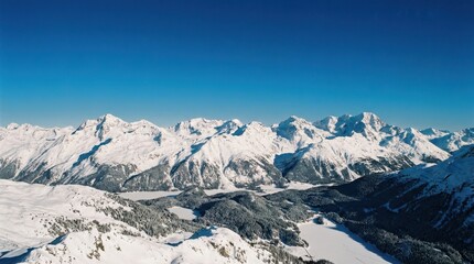 Naklejka premium Stunning panoramic winter landscape of snow-capped mountains and frozen lakes under a clear, bright blue sky