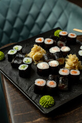A beautifully arranged platter showcases various sushi rolls filled with fresh ingredients. Accompanied by pickled ginger and vibrant wasabi, this culinary delight invites sharing and enjoyment