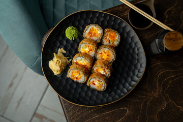 Savor the artistic presentation of crunchy sushi rolls filled with fresh ingredients, served with ginger and wasabi, accompanied by soy sauce in an inviting atmosphere