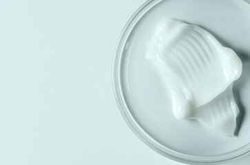 Moisturizing cosmetic skin cream in a Petri dish. Copy space