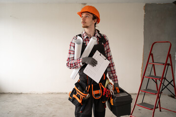 Home repair concept. Young laborer handyman wearing helmet hold toolbox holding Instruments...