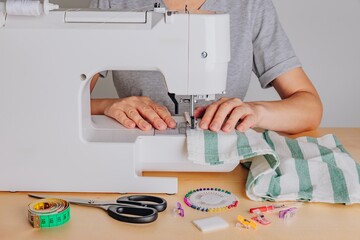 A Tailor's Craft: Operating a Sewing Machine with Various Tools and Materials for Fabric Creation and Modification
