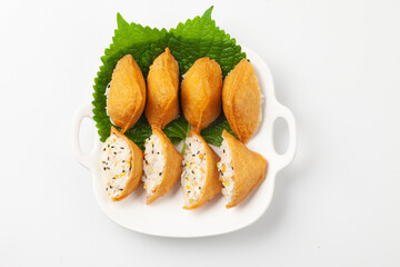  초를 친 밥에 다진 채소와 고기를 섞어 뭉친 것을 유부 속에 넣어 만든 음식.
A food made by mixing chopped vegetables and meat with rice and stuffing it into fried tofu.