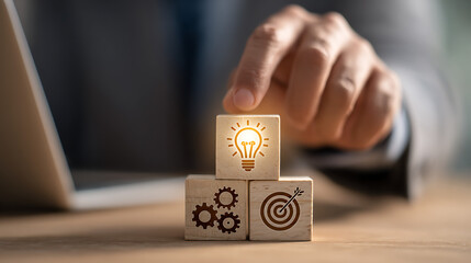 Person placing lightbulb cube on gears and target blocks hand business