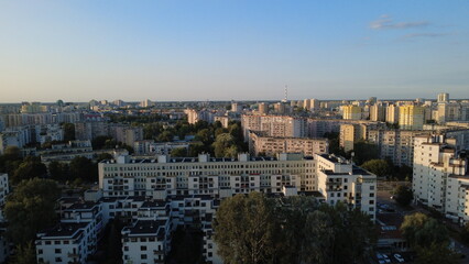 
Smooth drone footage flying toward the Warsaw city skyline during a warm summer sunset. The video captures the Vistula River, extensive green areas, residential neighborhoods, and a major highway fil