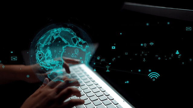 Close-up view of hands typing on a laptop keyboard with a digital globe and various data symbols surrounding, symbolizing advances in technology and global connectivity. Xenic - Powered by Adobe