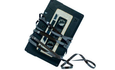 A retro audio cassette tape with its magnetic ribbon tangled and unwound, an iconic symbol of vintage music and obsolete recording technology
