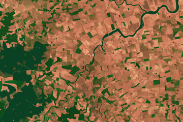 Aerial view of a winding river cutting through varied terrain and vegetation