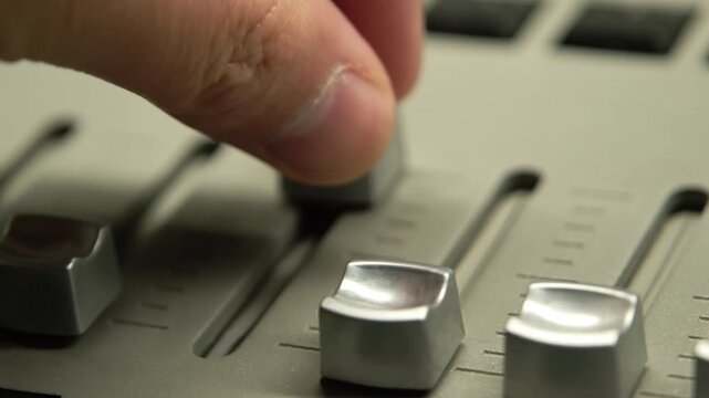 Lighting technician adjusting faders on a professional light mixer console