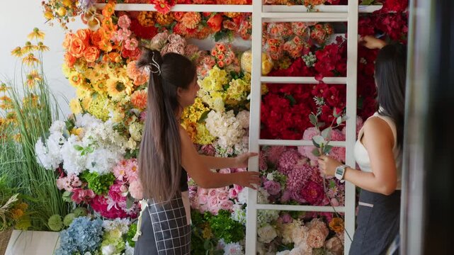 Candid moment of two women arranging flowers in a floral class