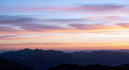A scenic landscape featuring silhouetted mountains under a vibrant sunset sky with colorful clouds.