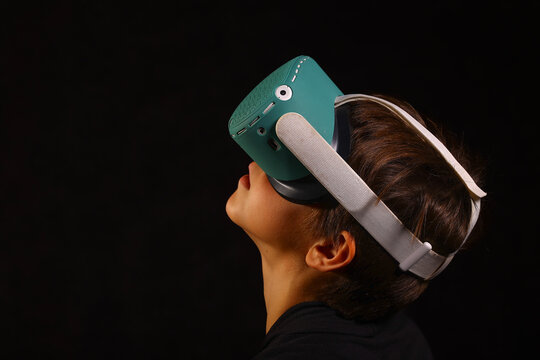Boy looking upward in VR headset while exploring virtual worlds, immersive futuristic gaming and modern technology concept
