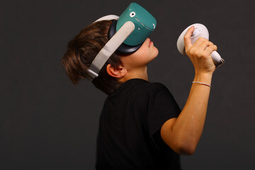 Boy wearing VR headset holding controller upward during immersive gaming session, modern...
