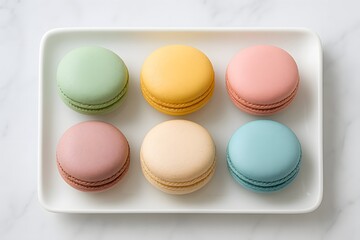 Obraz premium Pastel colored macarons on white rectangular plate