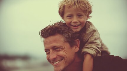 A father lifts his cheerful son on his back as they enjoy their day at the beach. Both are smiling and sharing a special moment as the sun sets in the background.