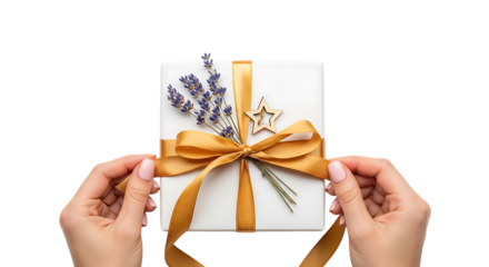 Hands tying a gold ribbon on a gift box decorated with lavender and a star isolated on white for a special occasion transparent background