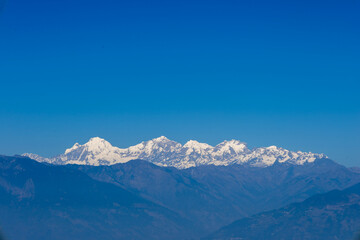 Majestic snow-capped mountain range under a clear blue sky, ideal for travel, tourism, adventure, hiking, trekking, nature background, climate, environment, inspiration and landscape concepts.