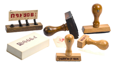 Assortment of vintage rubber stamps with wooden handles, arranged on a dark background