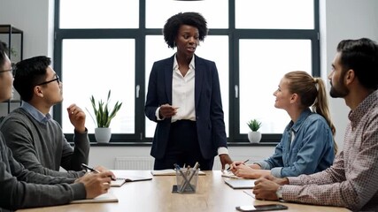 Senior female manager leads diverse creative team meeting for innovative project ideas