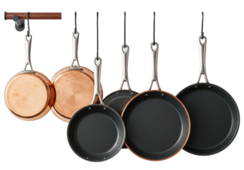 Premium copper frying pans, skillets, and crepe pans hanging on racks against a transparent background. Concept for high-end culinary advertising